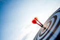 Close up shot red darts arrows in the target center on dark blue sky background. Business target or goal success and winner Royalty Free Stock Photo