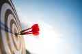 Close up shot red darts arrows in the target center on dark blue sky background. Business target or goal success and winner Royalty Free Stock Photo