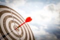 Close up shot red darts arrows in the target of dartboard center on dark blue sky background. Business target or goal success and Royalty Free Stock Photo