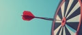 Close up shot red darts arrows in the target of dartboard center on dark blue sky background. Business target or goal Royalty Free Stock Photo
