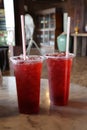 Close-up shot of red juice in a plastic glass with a straw, a refreshing drink concept in a throwable glass.