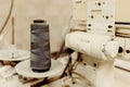Close up shot of a reel of thread lying beside a vintage sewing machine in a room Royalty Free Stock Photo