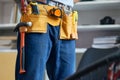 Close up shot of repairman wearing a toolbelt, getting ready for work, standing indoors Royalty Free Stock Photo