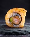 Close-up shot of a roll of sushi on a black stone plate Royalty Free Stock Photo