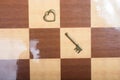 Close up shot of a romantic heart shaped vintage broken key on a chess pattern floor