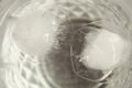 Close up shot of round-shaped ice cubes floating and melting in a transparent glass of water Royalty Free Stock Photo