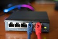 Close-up shot of a router - a red cable is connected next to the blue Ethernet cable. Concept of cabling, internet network,