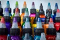Close-up shot of rows of colorful tattoo inks in plastic bottles