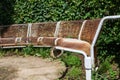 Close up shot of rusty metal benches in a circle without people in a park