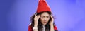 Close-up shot of sad and sick cute stylish woman in red warm beanie close eyes rubbing temples feeling tired and