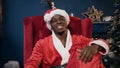 Close up shot of santa claus in the red hat holding the gift box and smiling to the camera.