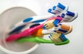 Close up shot of set of multicolored toothbrushes in glass on cl Royalty Free Stock Photo