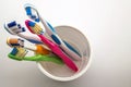 Close up shot of set of multicolored toothbrushes in glass on cl Royalty Free Stock Photo