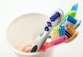 Close up shot of set of multicolored toothbrushes in glass on cl Royalty Free Stock Photo