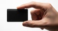 Hand holding a small black rectangular object with a smooth surface Royalty Free Stock Photo