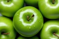 Close-up of a granny smith apple with water drops on its skin, surrounded by other apples Royalty Free Stock Photo