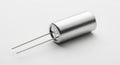 A Single Cylindrical Electronic Capacitor with Two Metal Leads on a Light Gray Surface Royalty Free Stock Photo