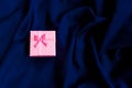 Close up shot of small gift wrapped with pink ribbon Royalty Free Stock Photo