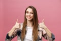 Close-up shot of smiling pretty girl showing thumb up gesture. Female isolated over pink background in the studio. Royalty Free Stock Photo