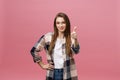 Close-up shot of smiling pretty girl showing thumb up gesture. Female isolated over pink background in the studio. Royalty Free Stock Photo