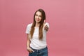 Close-up shot of smiling pretty girl showing thumb up gesture. Female over pink background in the studio. Royalty Free Stock Photo