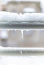 Close-up shot of snow accumulation on the window sill and an icicle.