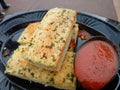 Close up shot of some grilled garlic bread with tomato sauce