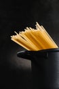 close-up shot of spaghetti boiling in black pan