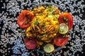 Close up shot of spicy tasty sabudana khichdi or sago ball khichdi along with some sliced tomatoes, some cut lemons in a glass