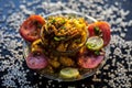 Close up shot of spicy tasty sabudana khichdi or sago ball khichdi along with some sliced tomatoes, some cut lemons in a glass