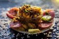 Close up shot of spicy tasty sabudana khichdi or sago ball khichdi along with some sliced tomatoes, some cut lemons in a glass pla