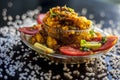 Close up shot of spicy tasty sabudana khichdi or sago ball khichdi along with some sliced tomatoes, some cut lemons in a glass pla