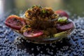 Close up shot of spicy tasty sabudana khichdi or sago ball khichdi along with some sliced tomatoes, some cut lemons in a glass pla