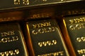 Close up shot of stacked 999.9 pure gold bar ingot on a black background