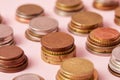 close-up shot of stacks of various coins on pink