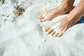 Close up shot of tanned feet on the white sandy beach