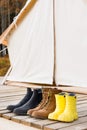 Close-up shot of three different pair of shoes near a canvas tent Royalty Free Stock Photo