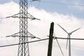 Close up shot of three different types of energy, old electric post, modern electric post and wind turbine.