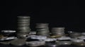 Close up shot of three stacks of silver old coins with a dark background