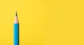 Close-up of a sharpened blue pencil against a vibrant yellow background writing drawing Royalty Free Stock Photo