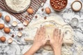 Close-up shot. Top view of a baker cook place, hands are working with a raw dough on the marble table background. Royalty Free Stock Photo