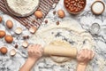 Close-up shot. Top view of a baker cook place, hands are working with a raw dough on the marble table background. Royalty Free Stock Photo