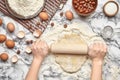 Close-up shot. Top view of a baker cook place, hands are working with a raw dough on the marble table background. Royalty Free Stock Photo