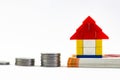 Close up shot of a toy house on note bundle and piled up coins in Home Loan concept Royalty Free Stock Photo