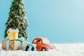 close-up shot of toy red car with presents and christmas tree standing on snow made of cotton