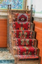 Close up shot of a traditional handmade carpet on wooden stairs Royalty Free Stock Photo