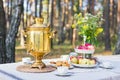 Close-up shot of a traditional russian samovar with cups on a table with snacks