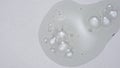 Close up shot of transparent substance on the white background. Cosmetic product gel or serum with bubbles on the
