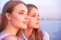 Two pretty women enjoying amazing colors of sunset