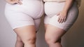 Close up of an overweight two women in tight clothes., plus size female waistline, belly, body positivity